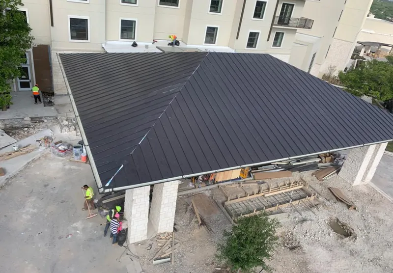 Metal roofing installation team working on a commercial building in Greenbelt